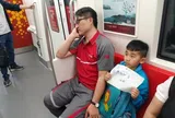 Bố làm shipper ngủ gật, bé trai giơ tờ giấy "Xin mọi người nói nhỏ" trên tàu điện, dân mạng: Đây mới là ông bố "giàu có"