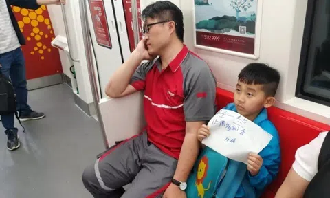 Bố làm shipper ngủ gật, bé trai giơ tờ giấy "Xin mọi người nói nhỏ" trên tàu điện, dân mạng: Đây mới là ông bố "giàu có"