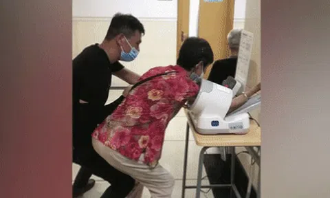 Con trai hiếu thảo lấy thân mình làm ghế cho mẹ già ngồi trong bệnh viện
