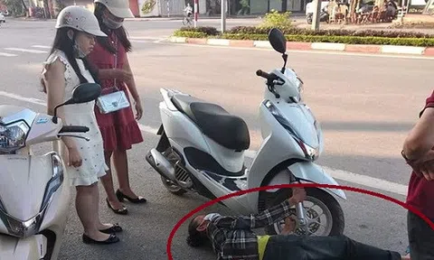 Dân mạng xôn xao trước hình ảnh người phụ nữ nằm giữa đường ôm chặt bánh xe máy