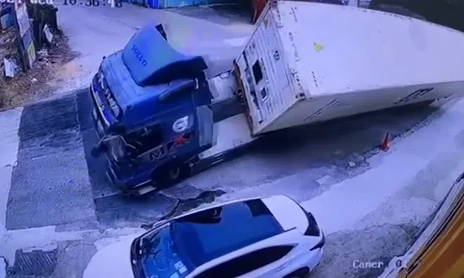 Clip: Bị lật nghiêng khi vào cua, container đè bẹp ô tô con